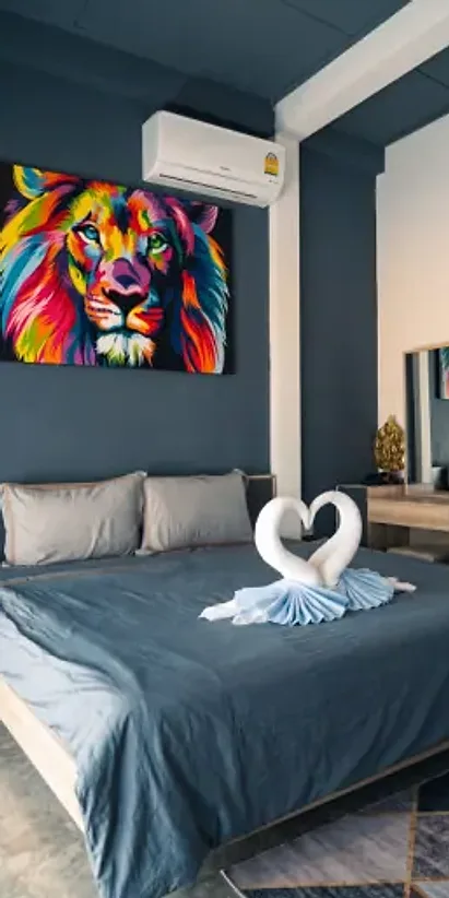 A bedroom in Cottage A with a bright lion painting above the bed