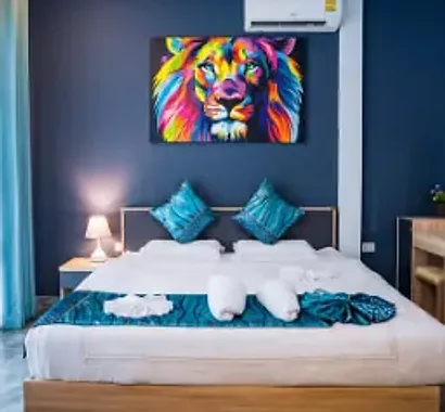 A bedroom in Cottage B with teal cushions and a white bed